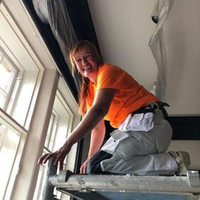 Työntekijä maalaa ikkunakarmeja