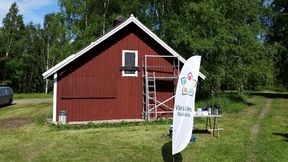 Kahvipöytä ja Värisilmän mainosteline punaisen puuvajan edessä