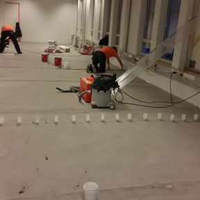 Työntekijät rakentavat liiketilan lattiaa